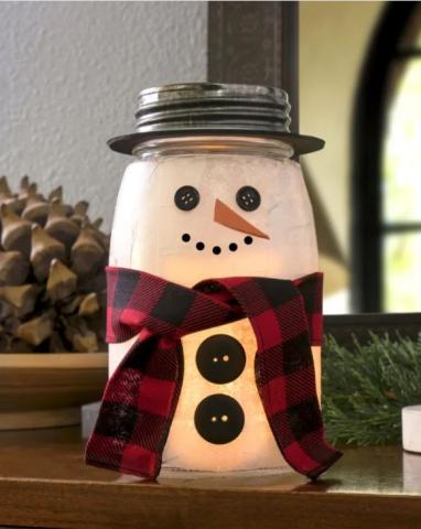 Photo of a snowman craft created from a mason jar, paint, buttons, and fabric.