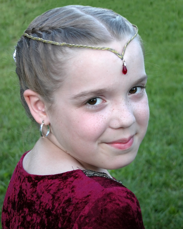 Girl child dressed in red renaissance dress smiling 