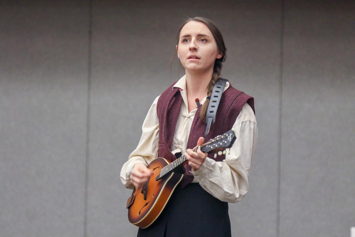 woman in a vest holding a mandolin