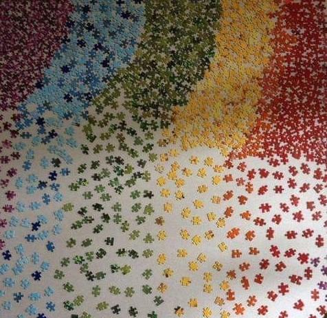 a variety of rainbow colored puzzle pieces set against a white background